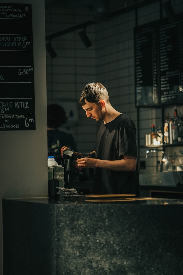 Small business owner standing proudly outside his shop